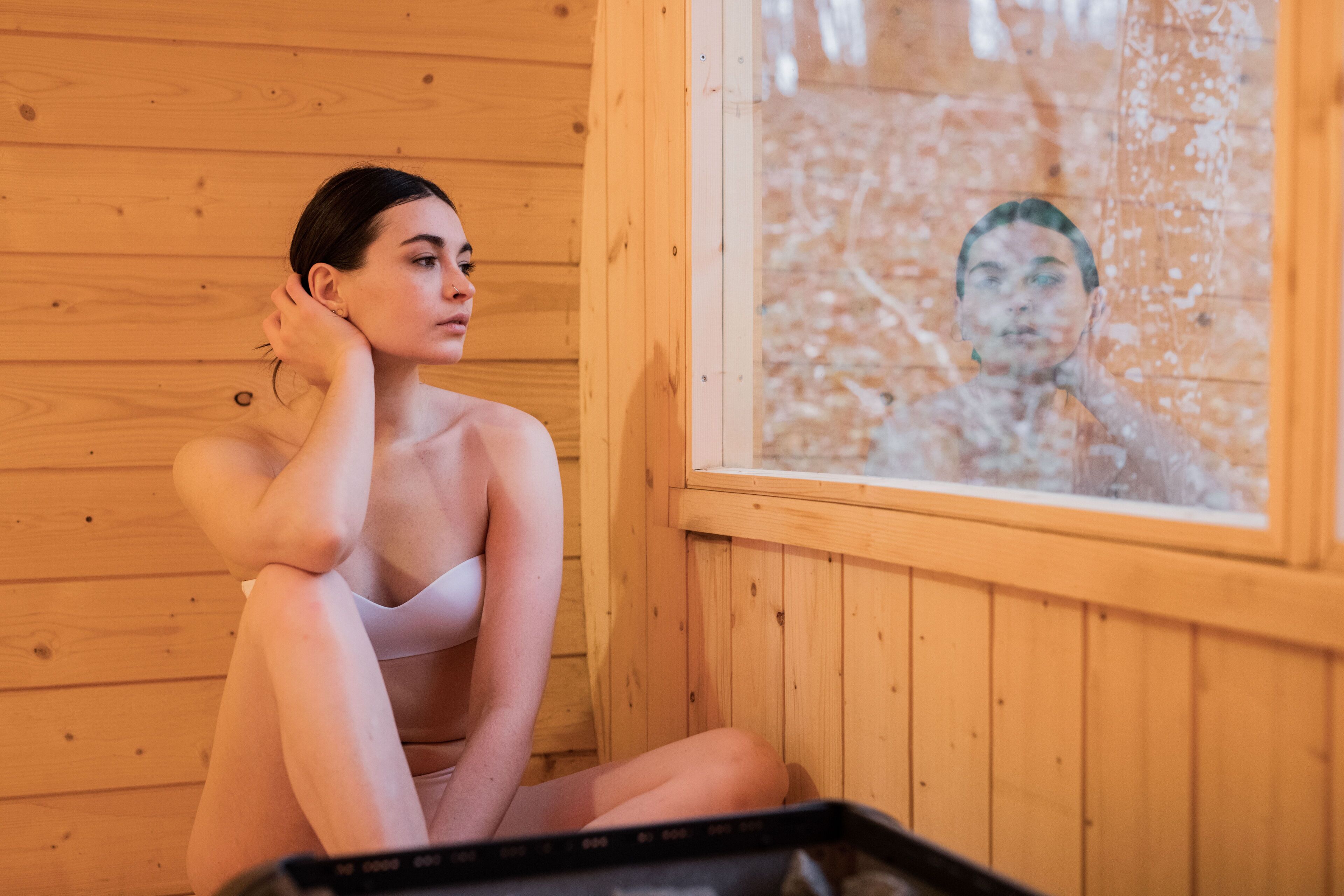 Una persona sentada junto a una ventana en una habitación de madera.