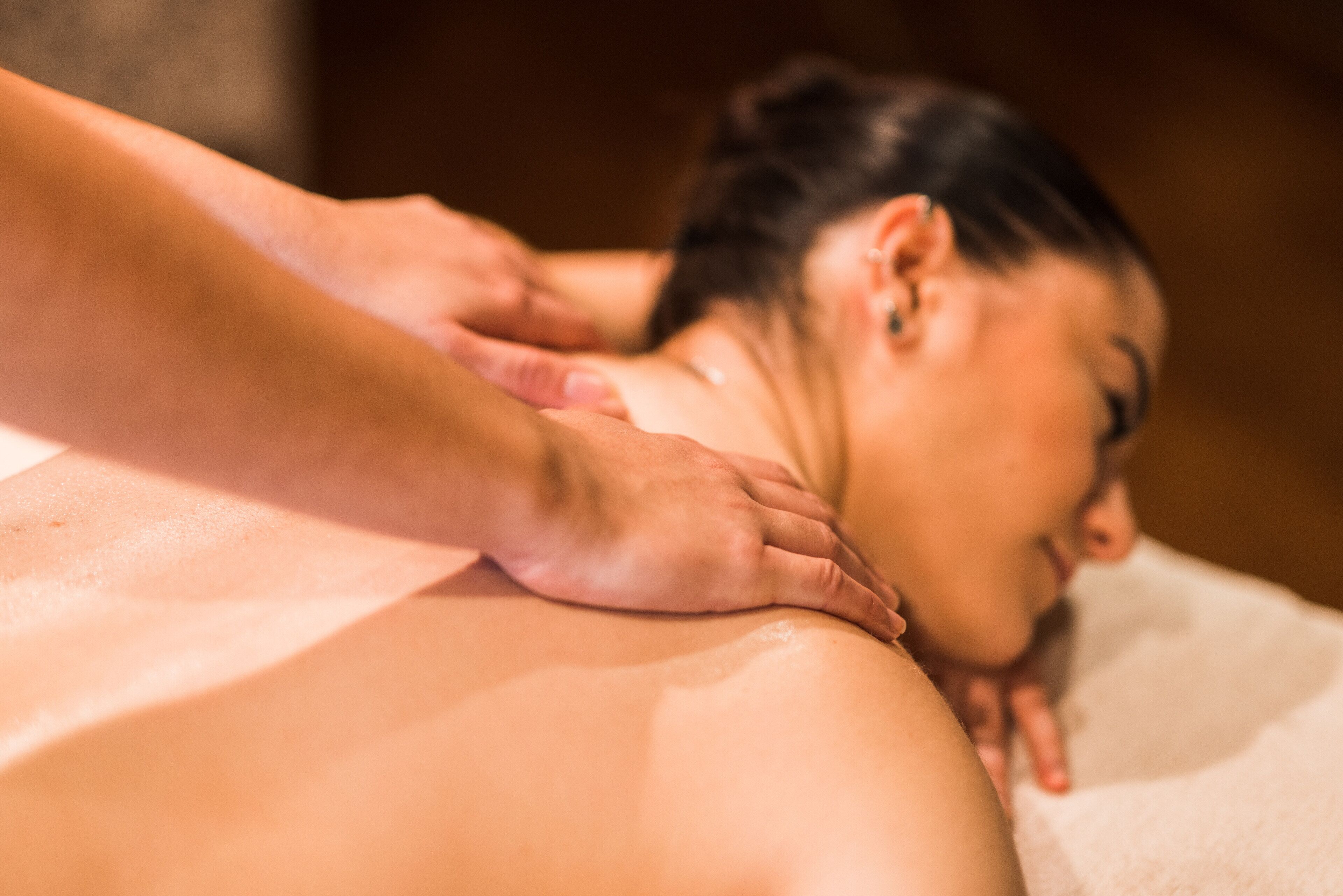 Una sesión de masoterapia con una persona recibiendo un masaje en la espalda.