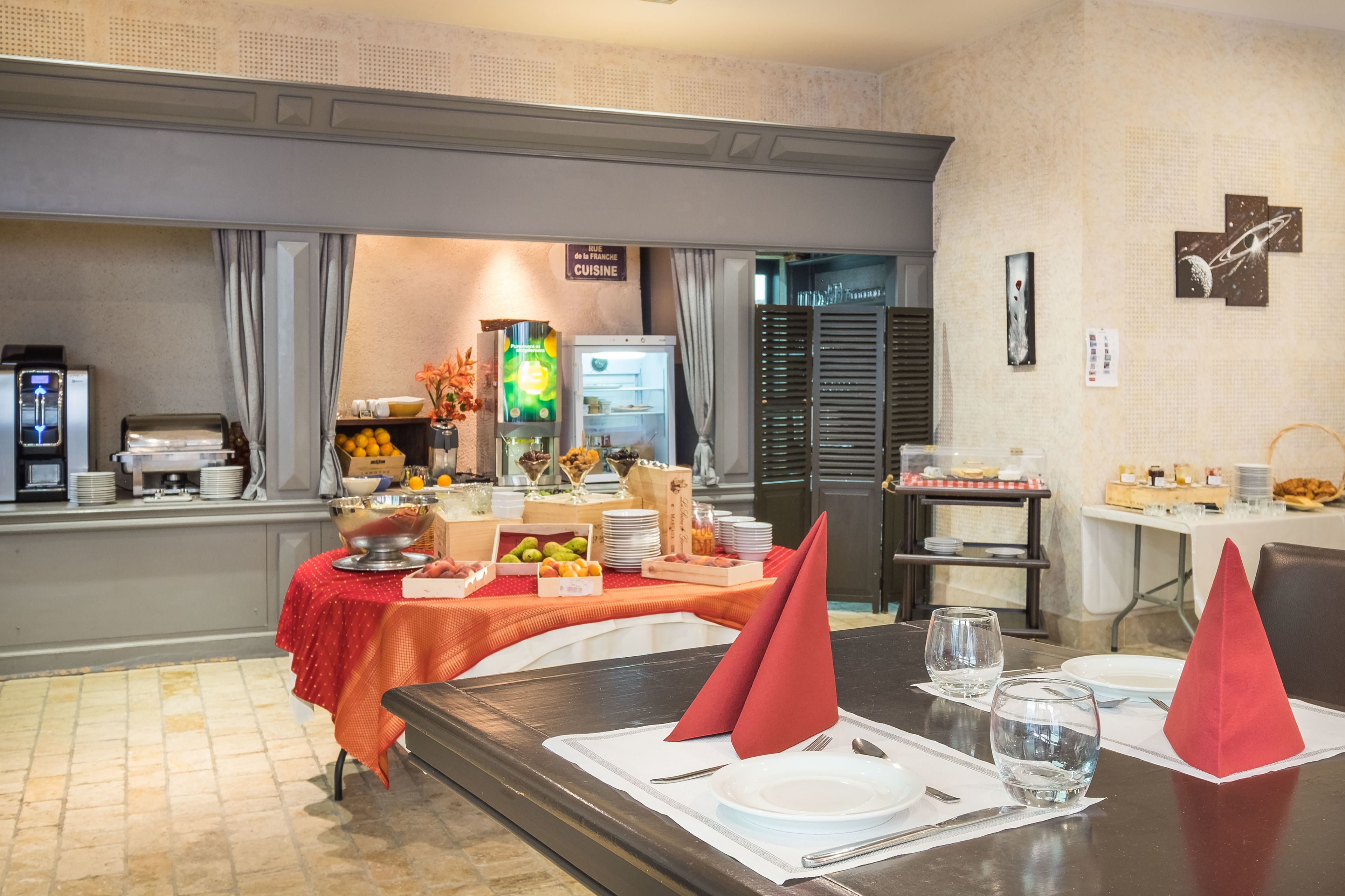 Un bufé de desayuno con diversos alimentos, una máquina de café y un refrigerador.