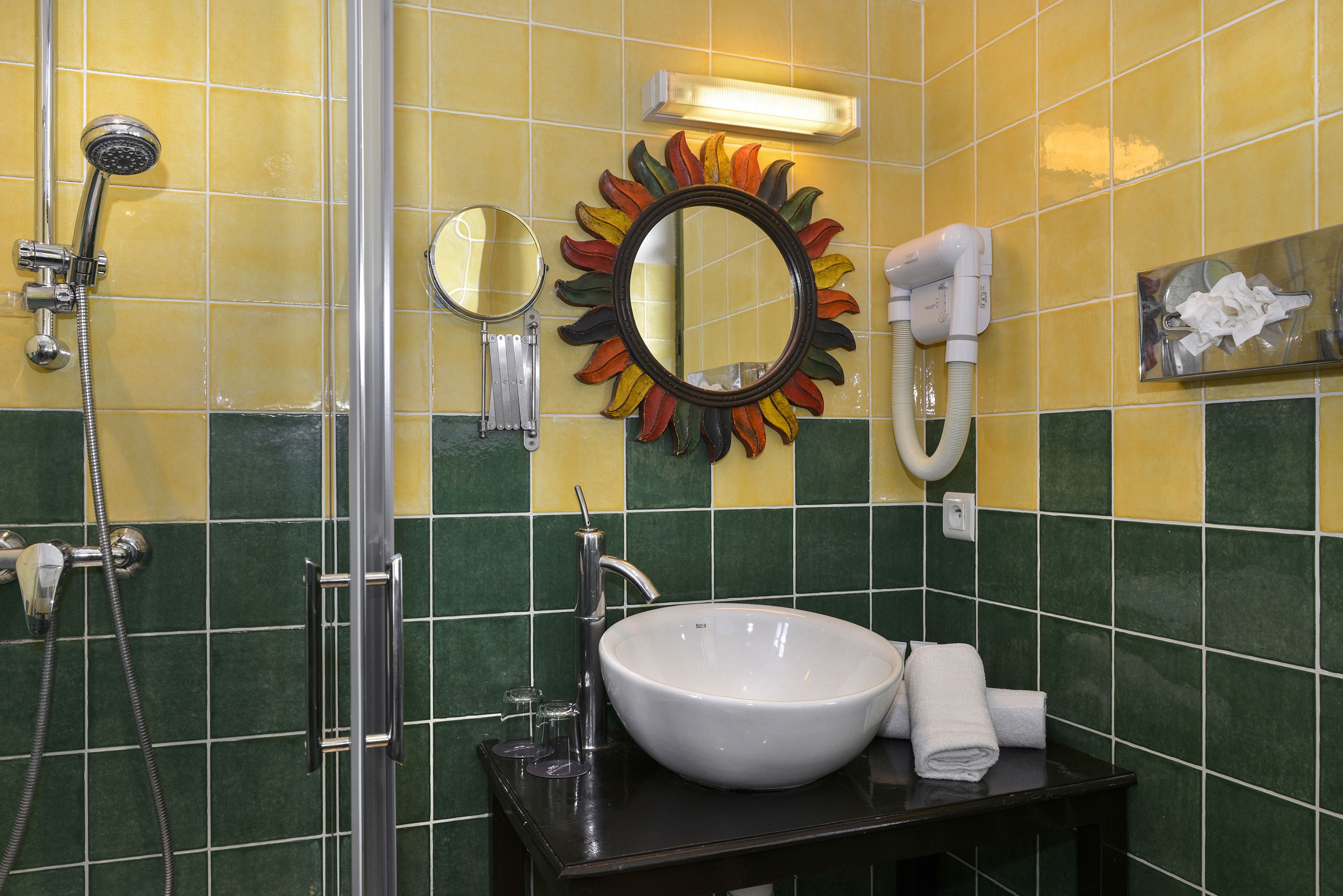 A bathroom with a sink, mirror, and shower.