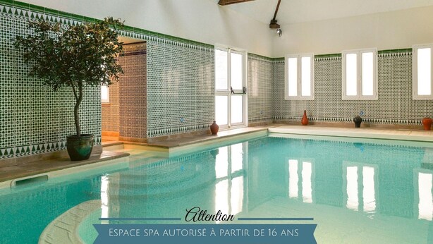 A spa pool area with tiled walls and wooden beams.