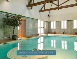 Un espace de piscine de spa avec des murs carrelés et des poutres en bois.