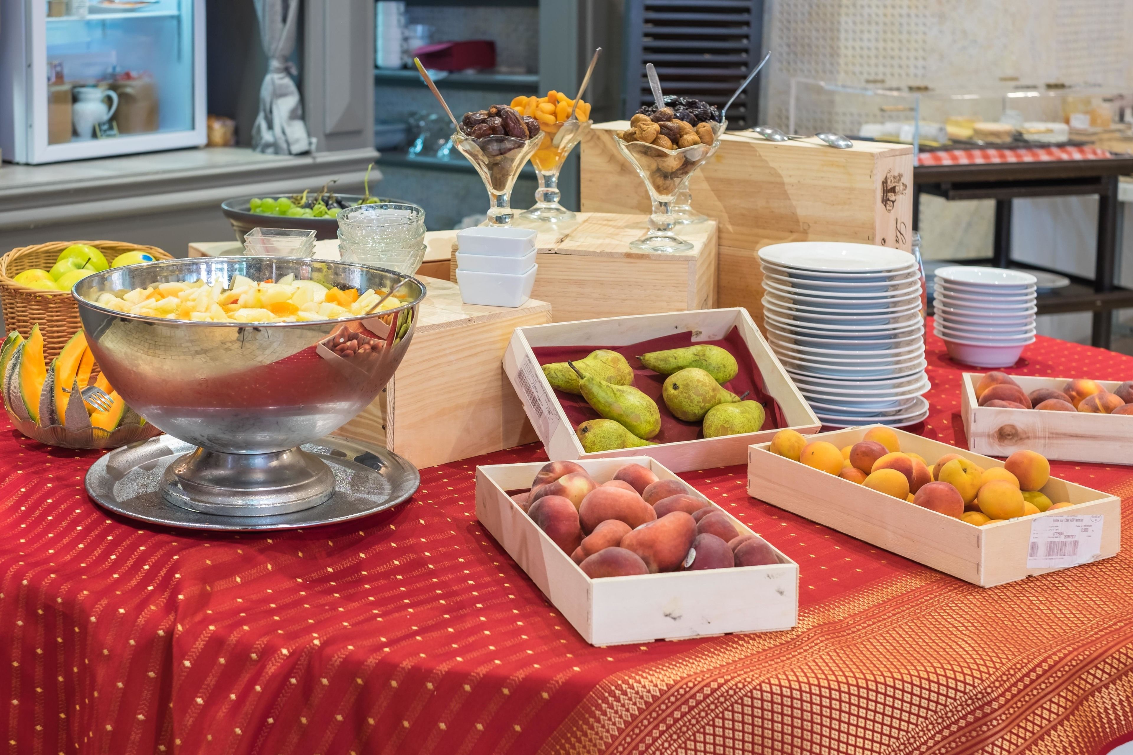 Una mesa de buffet con diversas frutas y postres.