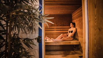 Un sauna avec des bancs en bois et une plante au premier plan.