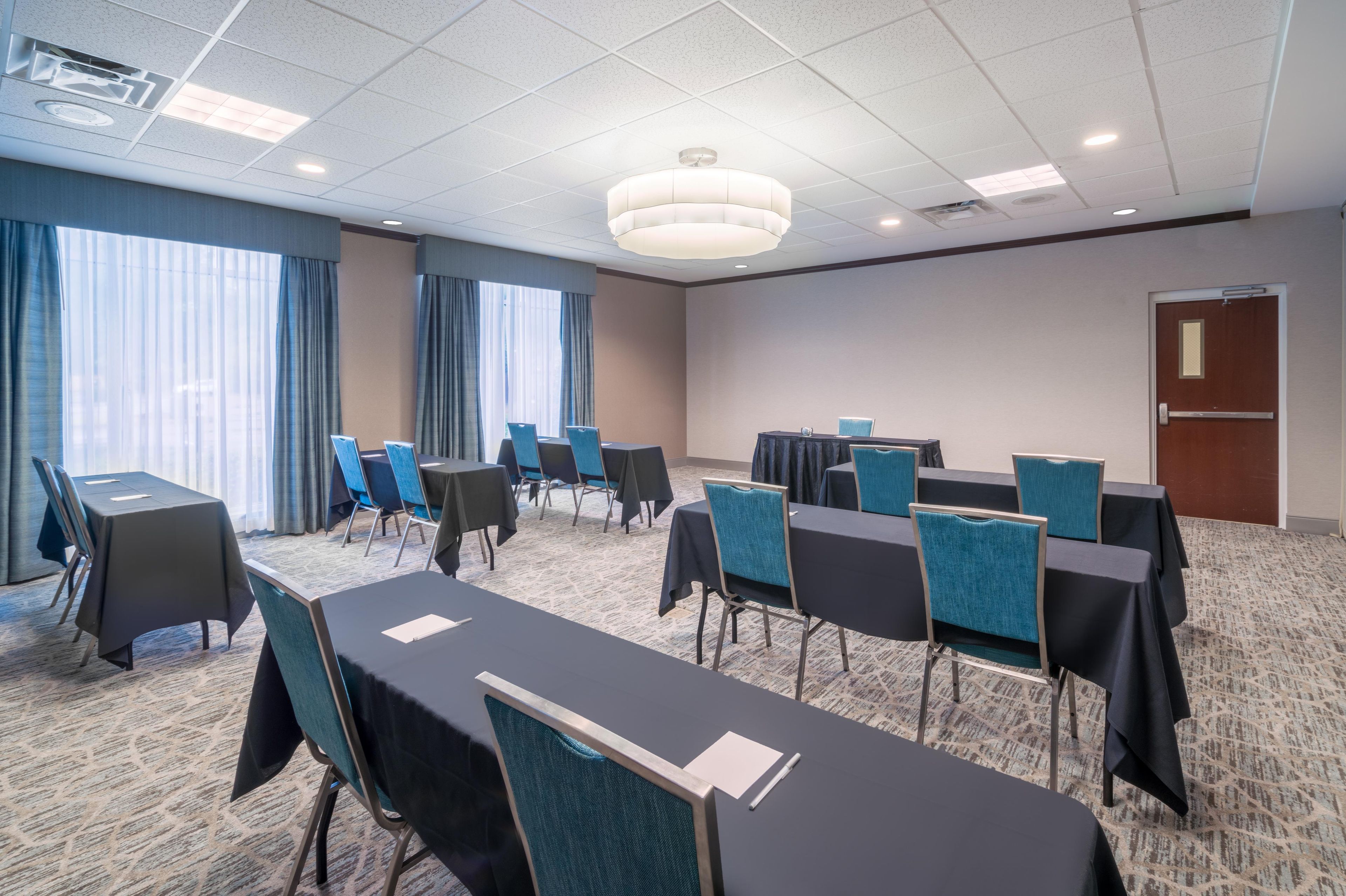 Une salle de conférence avec une longue table, des chaises et une porte.
