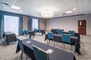 A conference room with a long table, chairs, and a door. - Hilton Garden Inn Augusta (Augusta)