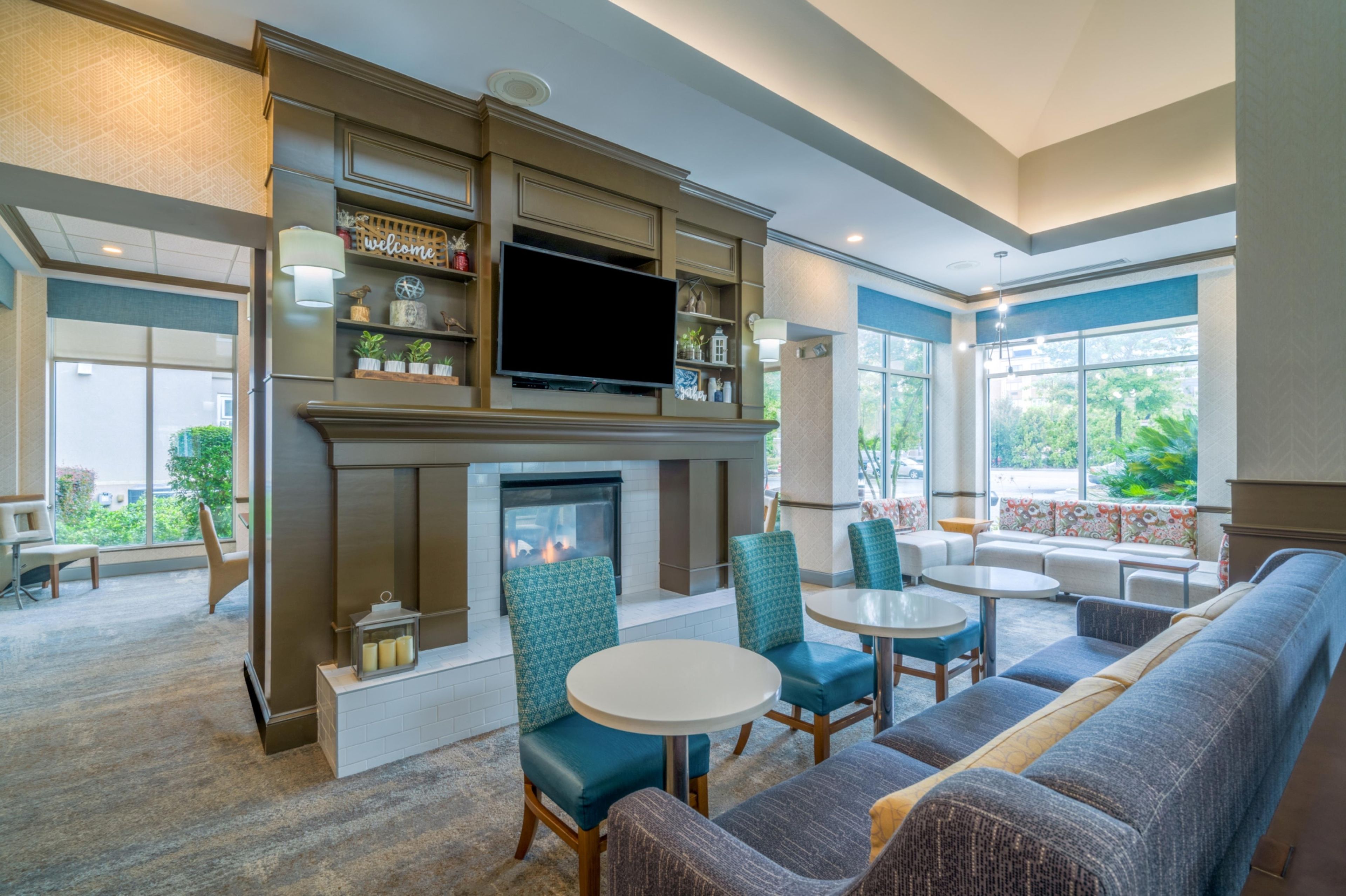 A modern lounge area with a fireplace, comfortable seating, and a flat-screen TV.