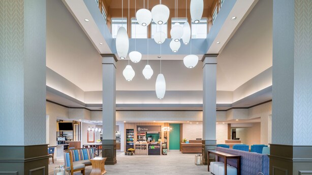 A spacious lobby with a central seating area, a shop, and a reception desk. - Hilton Garden Inn Augusta (Augusta)