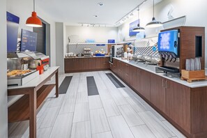 A modern kitchen with a coffee machine, a fruit display, and a counter with various items. - Holiday Inn Express & Suites West by IHG (Shreveport)