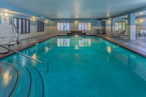 Una piscina techada, sillones reclinables de piscina
