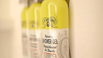 Una hilera de botellas amarillas con la etiqueta 'J.R. Watkins Refreshing Shower Gel'.
