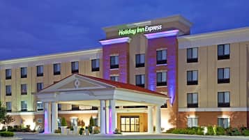 Welcome to the Holiday Inn Express, featuring a covered walkway entrance and a modern facade with a uniform window pattern.