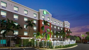 Un hotel Holiday Inn Express de varios pisos, con una fachada bien iluminada y un estacionamiento.