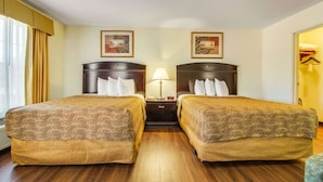 A hotel room with two beds, a nightstand, a lamp, and two framed pictures on the wall. - MainStay Suites Texas Medical Center/Reliant Park (Houston)