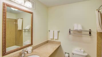 A bathroom with a sink, mirror, towel rack, and toilet.