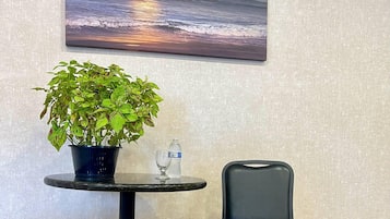 A table with a potted plant, a glass, and a bottle of water.