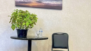 A round table with a potted plant, a glass, and a water bottle. - MainStay Suites Texas Medical Center/Reliant Park (Houston)