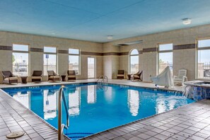 Relax by the pool, surrounded by lounge chairs and a hot tub.
