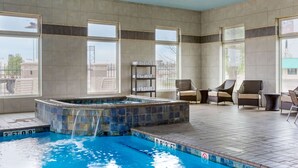 A swimming pool with a hot tub, tiled walls, large windows, and outdoor seating. - Comfort Inn & Suites Amarillo East (Amarillo)