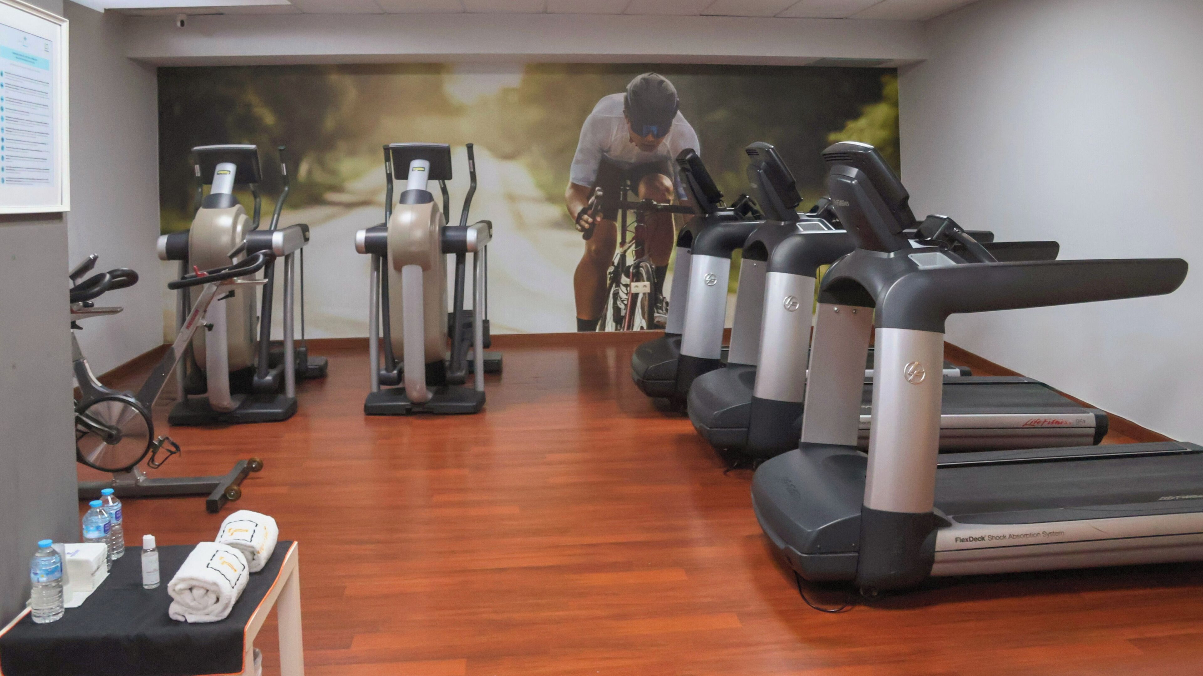 Un gimnasio con bicicletas estáticas, elípticas y cintas de correr.