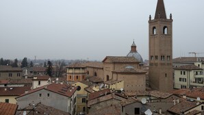 A historic town with a prominent church featuring a bell tower and a dome. - Masini Hotel (Forlì)