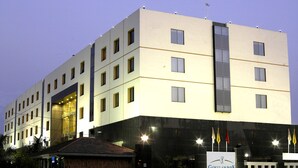 A multi-story hotel with a modern design, featuring a prominent entrance with glass doors and a signboard. - Gokulam Park Sabari OMR Hotel (Tirupporur)