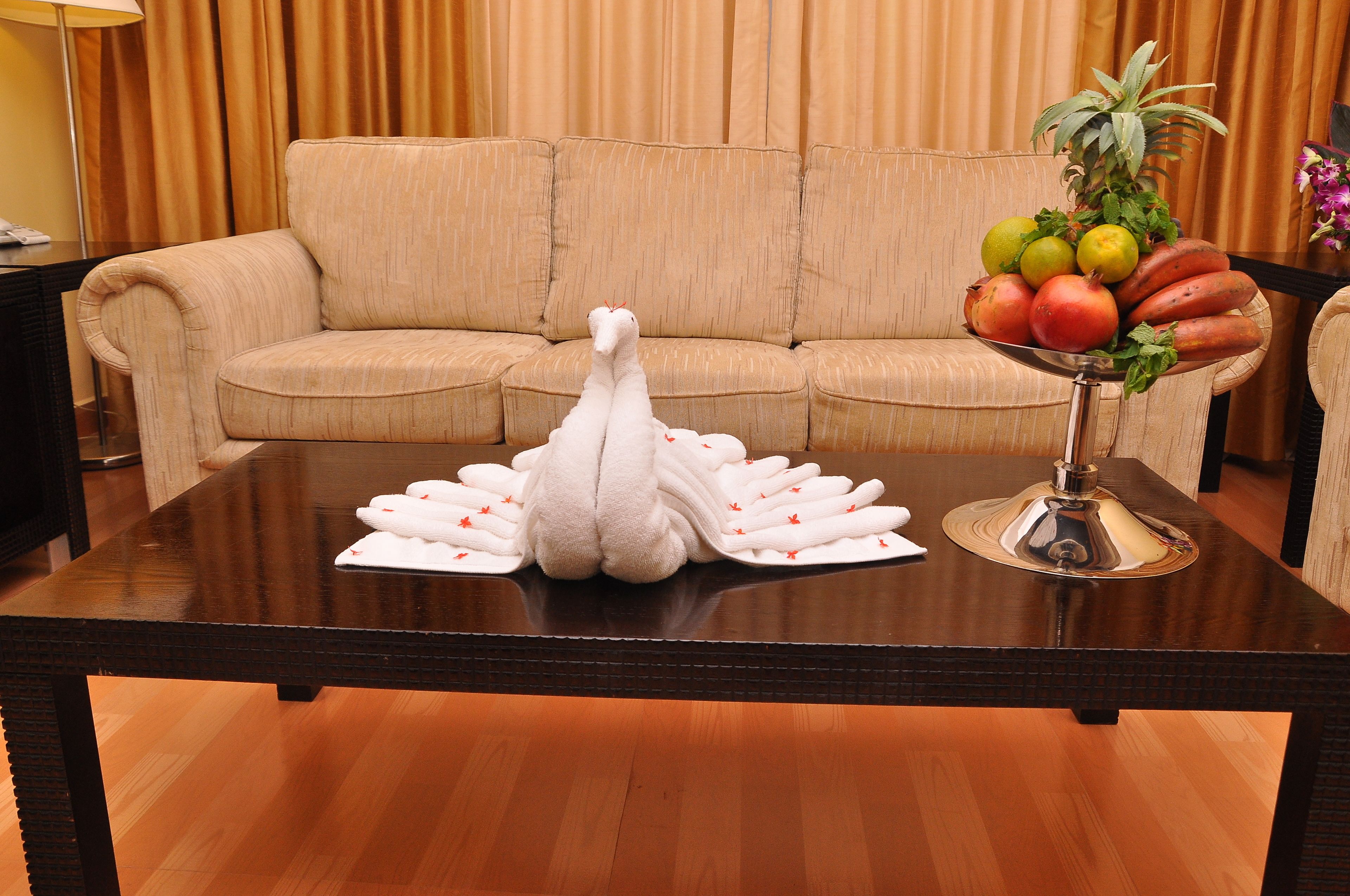Una mesa de comedor con un centro de mesa con forma de cisne blanco, un frutero y una lámpara.