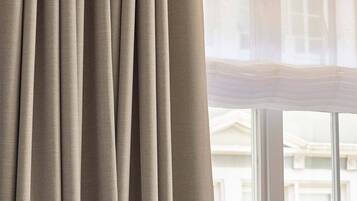 A window with curtains and a view of a building outside.