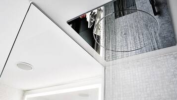 A modern interior with a white ceiling, a circular skylight, and a textured wall.