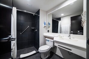 Et moderne badeværelse med bruseniche, toilet og vask.