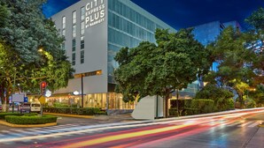 Un moderno edificio de hotel con un letrero llamativo que dice "CITY EXPRESS PLUS BY MARRIOTT".