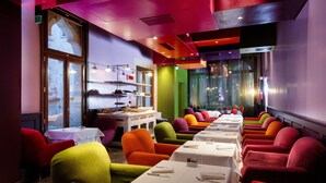 A restaurant with colorful chairs and tables, a large window, and a modern interior design. - Hotel Ca' Zusto Venezia (Venice)