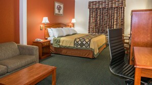 Une chambre d’hôtel avec un lit, un canapé, un bureau et une chaise.