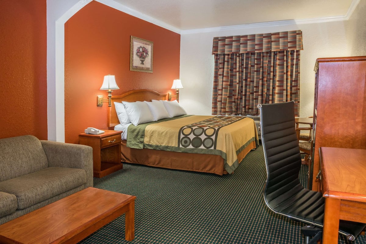 Een hotelkamer met een bed, een bank, een bureau en een stoel.