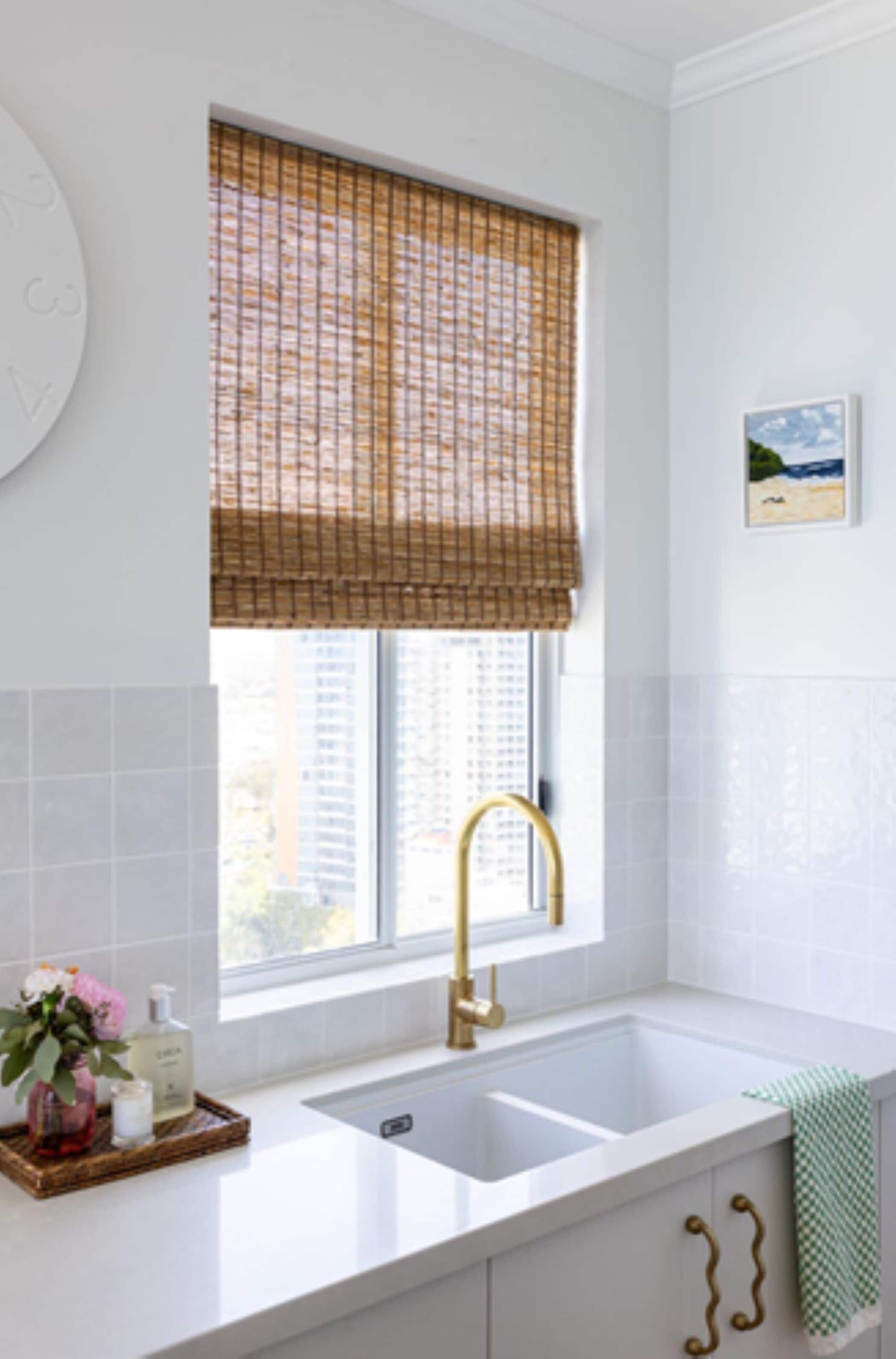 Una cocina con ventana, un lavabo y un grifo.