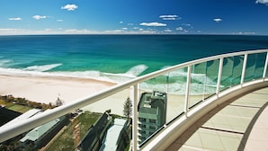 Un balcon avec vue sur une plage et l’océan.