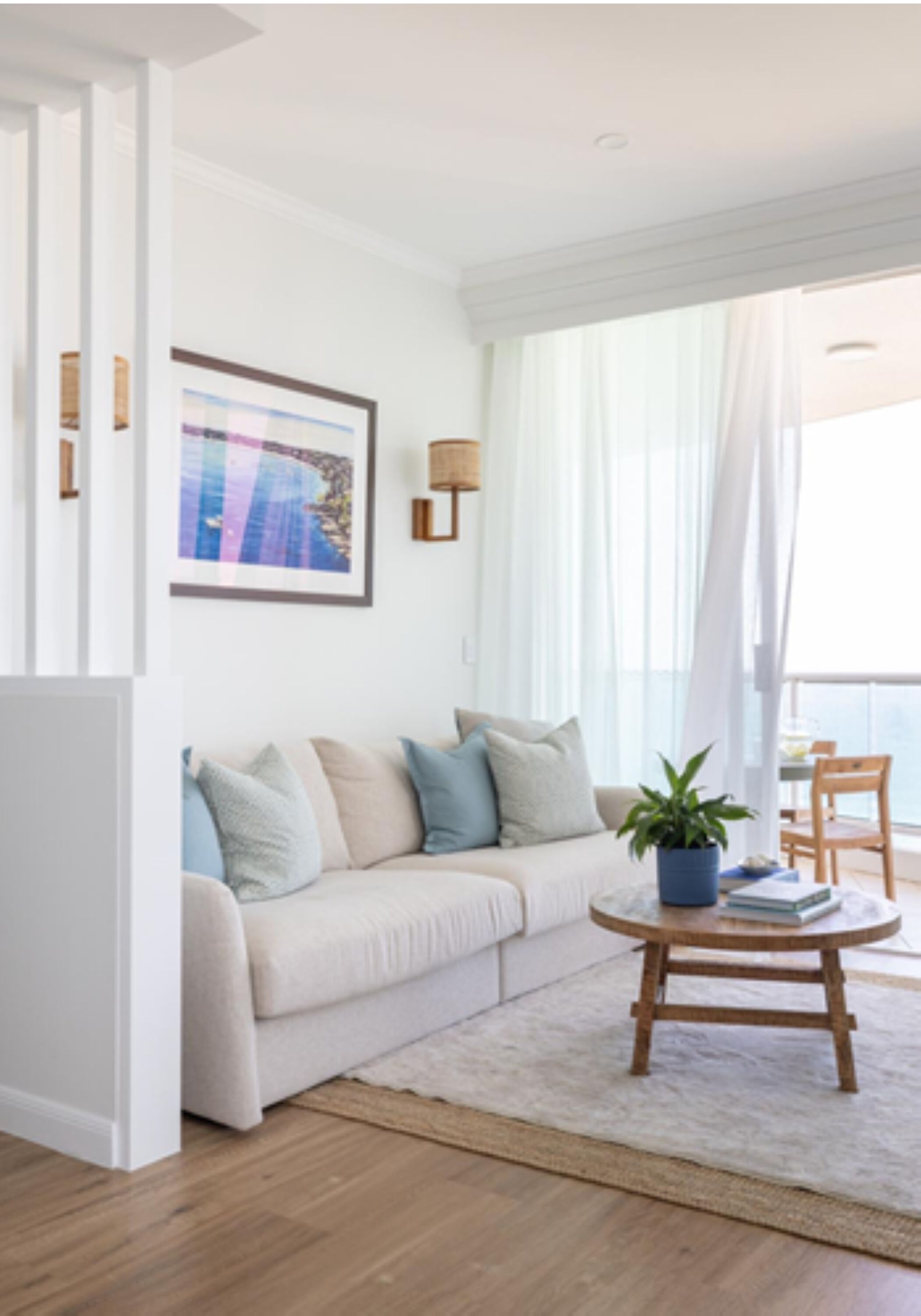 A modern living room with a sofa, a coffee table, and a potted plant.