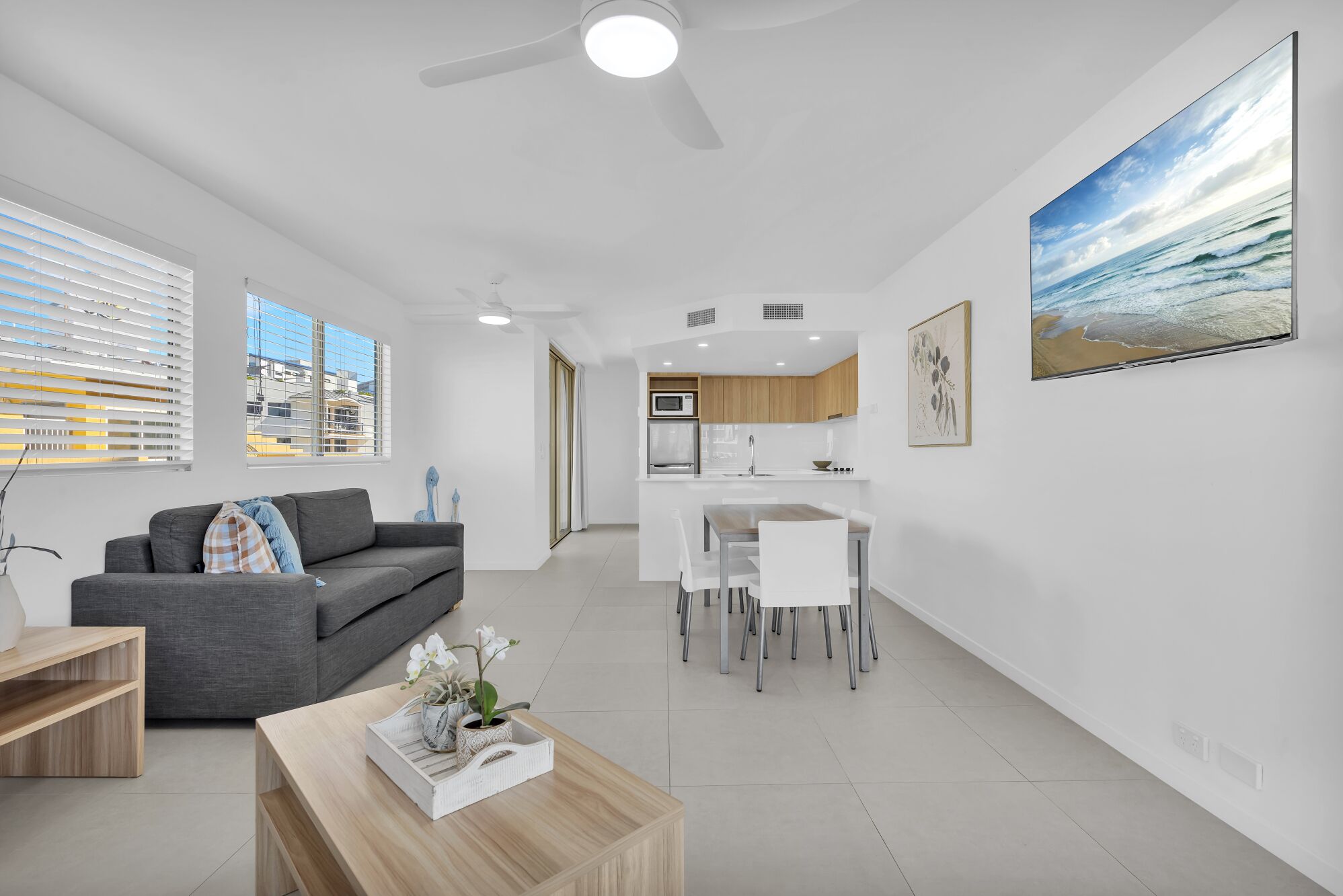 A modern apartment with a living room, dining area, and kitchen.