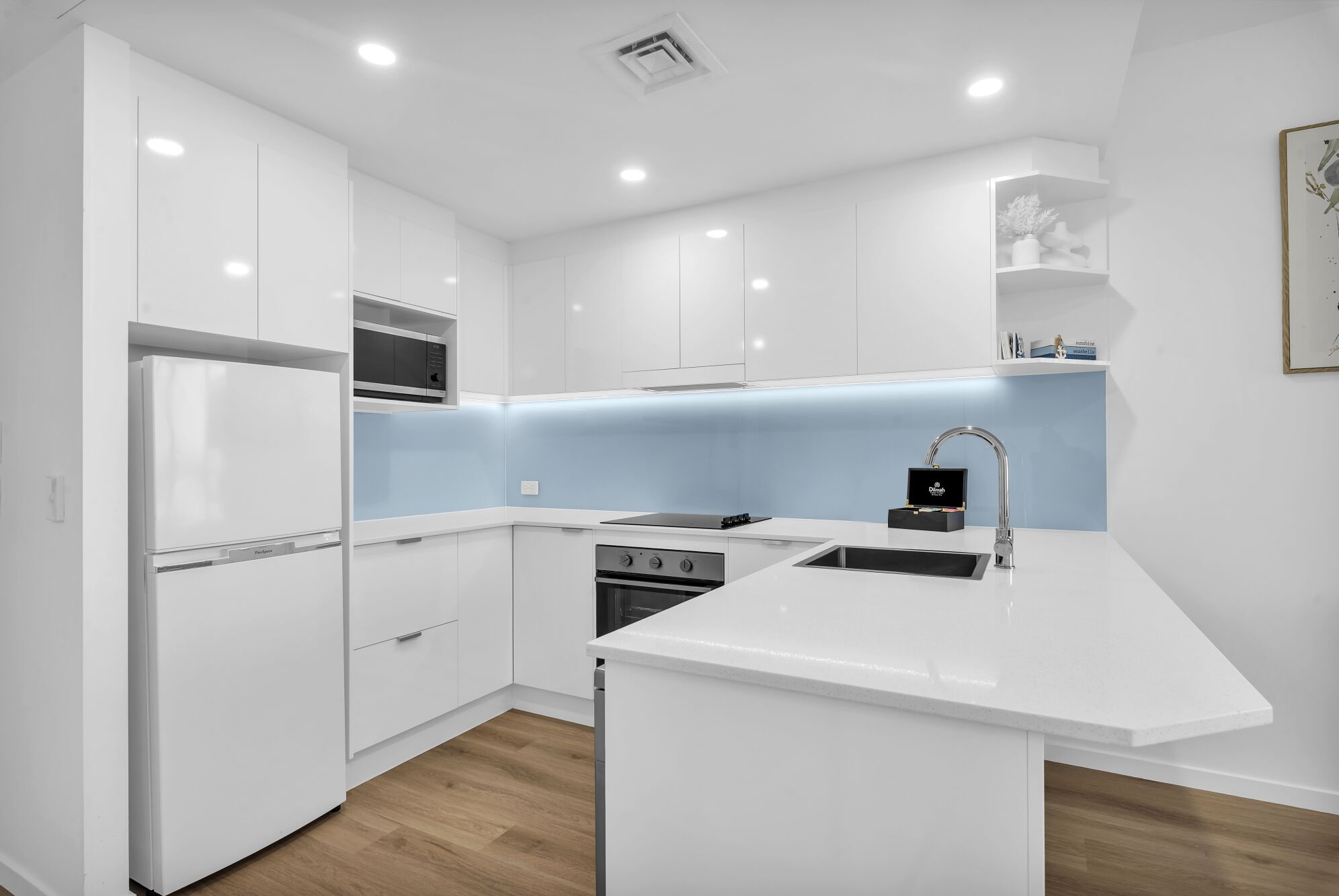A modern kitchen with white cabinetry, a built-in oven, a microwave, and a sink with a modern faucet.