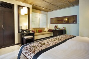 Una habitación de hotel con una cama grande, un sofá, un escritorio y un armario.