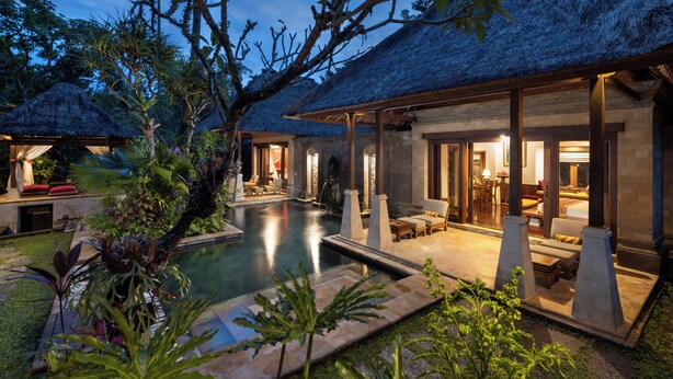A resort with a swimming pool, thatched-roof structures, and a well-lit outdoor seating area. - Arma Museum & Resort (Ubud)