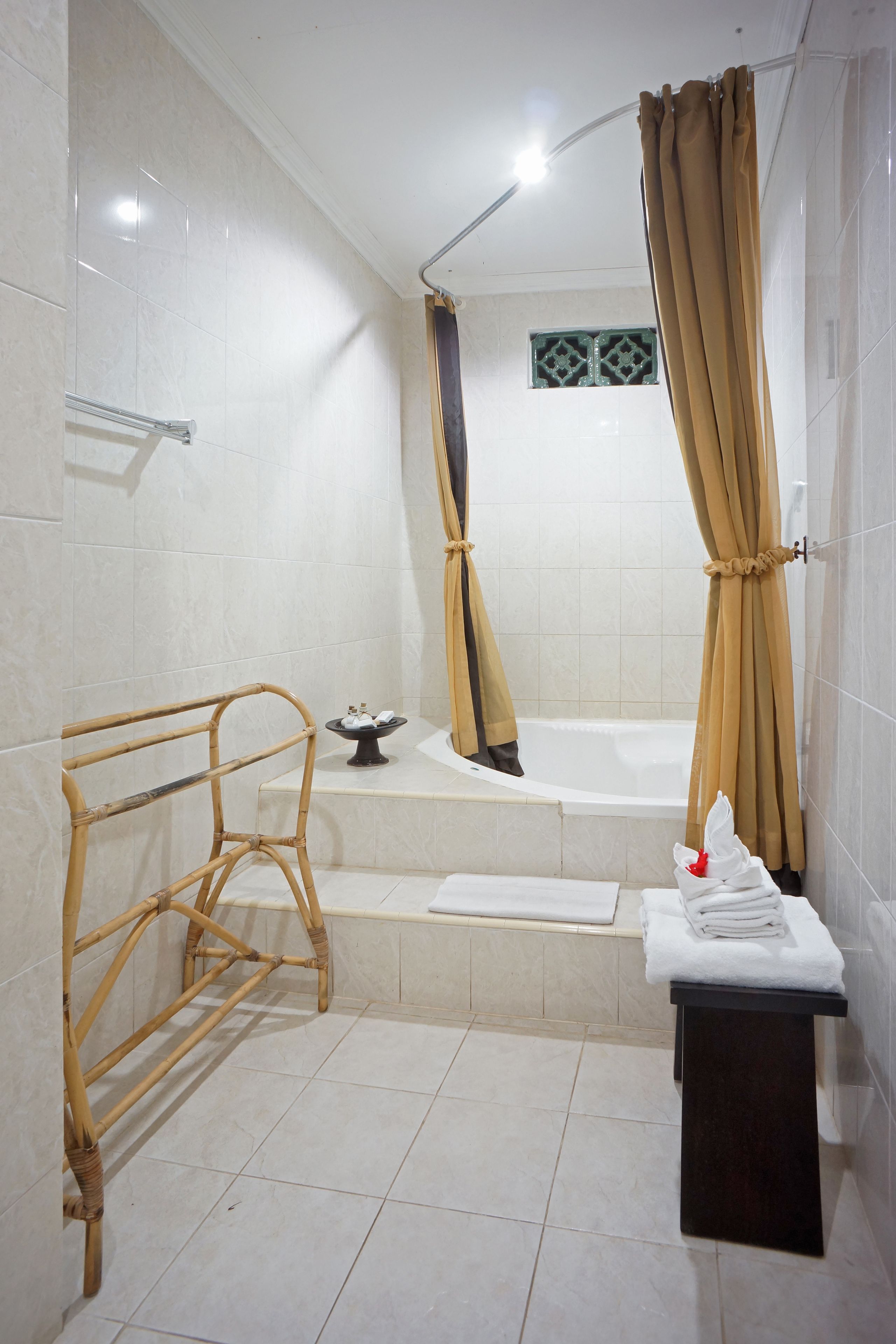 Un baño con bañera, cortina de ducha, toallero y un pequeño estante.