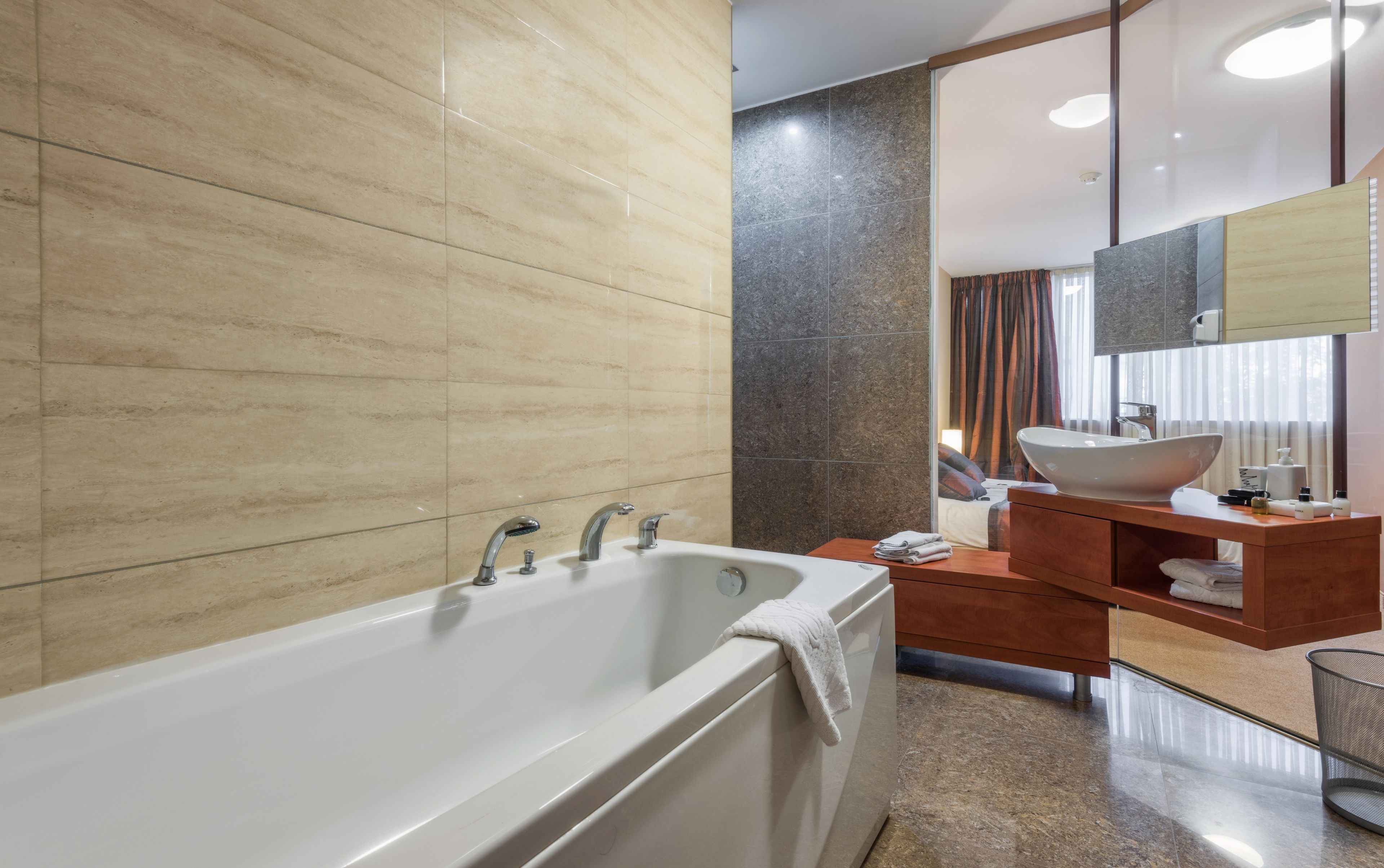 Ein modernes Badezimmer mit einer Badewanne, einem Waschtisch und einem großen Spiegel.