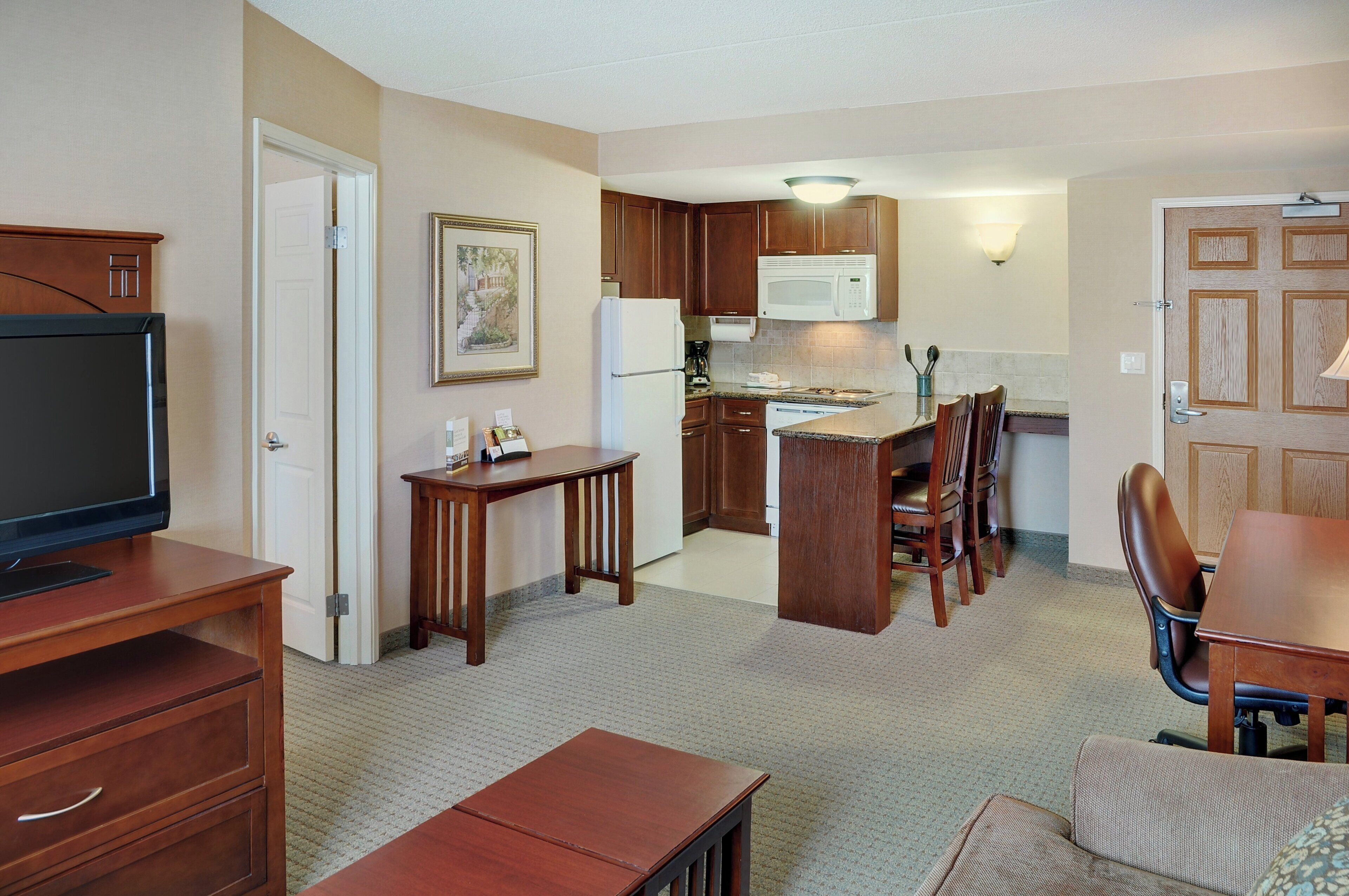 A compact living space with a kitchenette, a dining area, and a television.