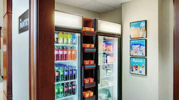 A vending machine area with a variety of beverages and snacks, including sodas and candy.