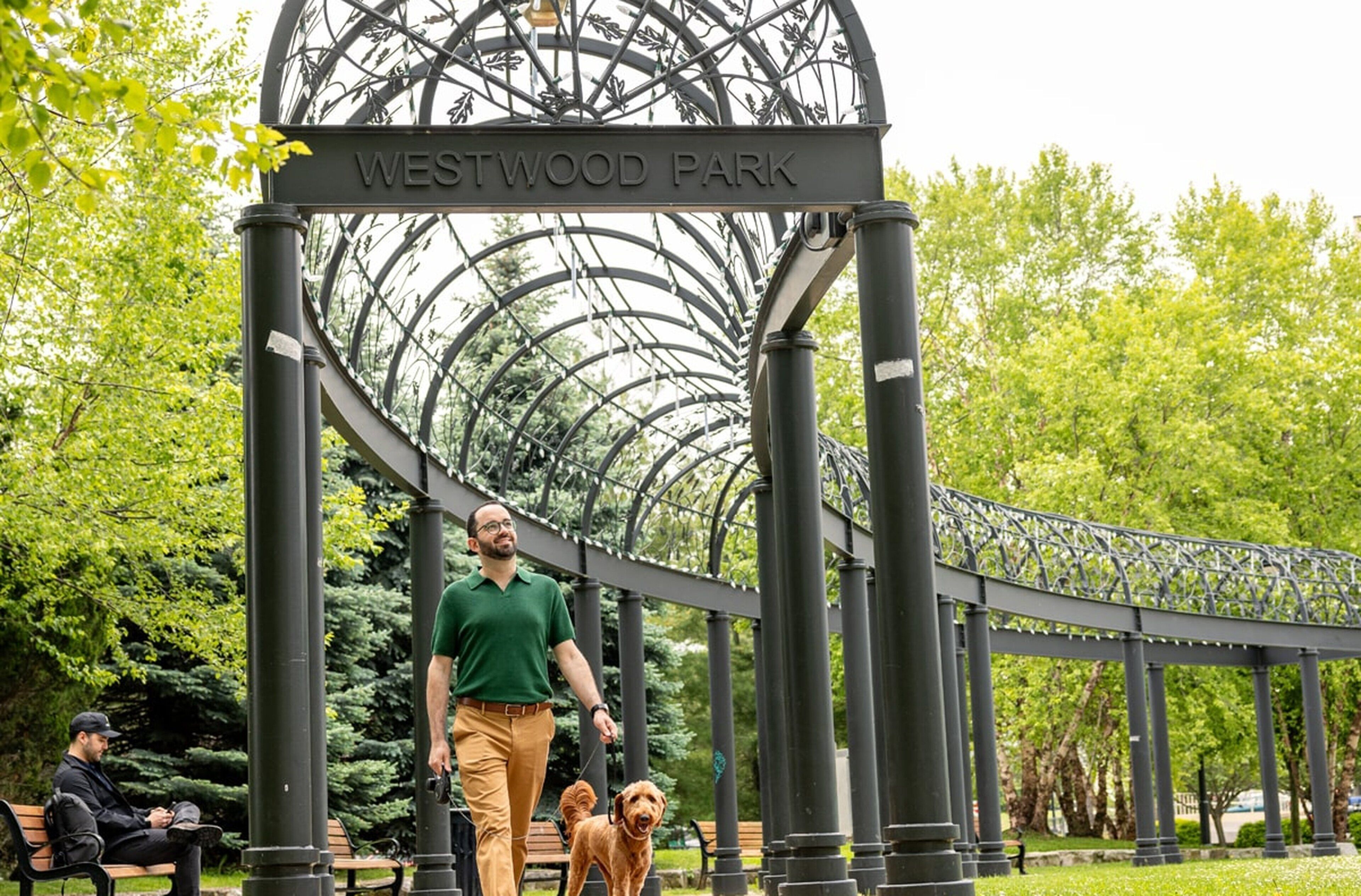 A park entrance with a metal archway and a sign reading 'Westwood Park'.