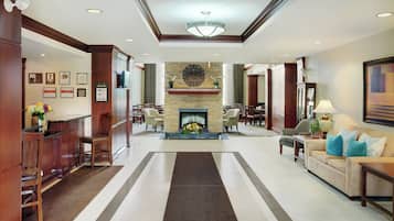 A spacious lobby with a fireplace, seating areas, and a reception desk.