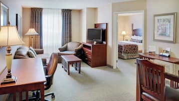 Une chambre d’hôtel équipée d’un bureau, d’une chaise, d’une télévision et d’un lit.