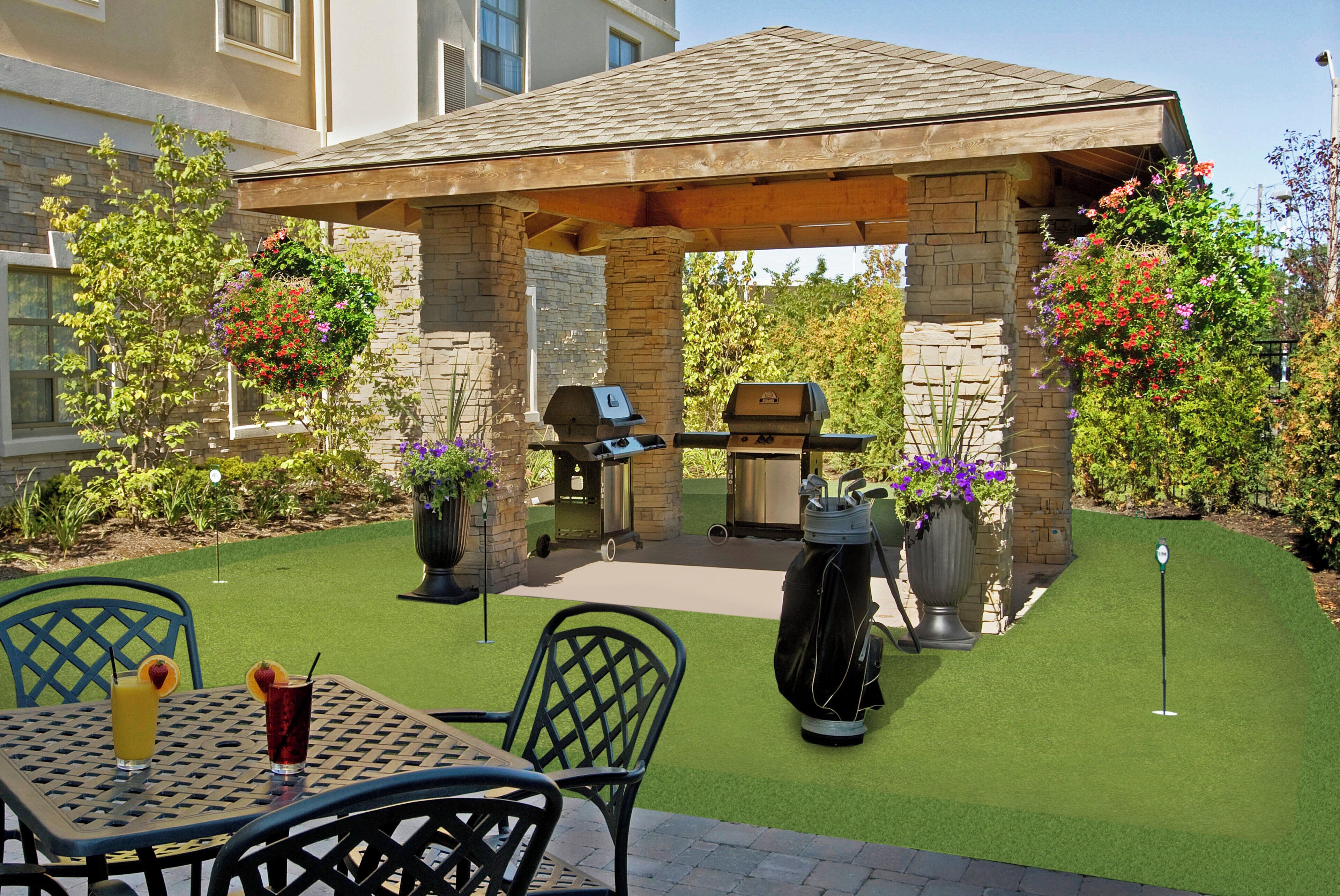 An outdoor patio with a pergola, a grill, and a golf cart.