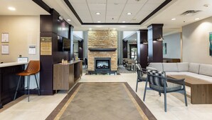 Een modern interieur met een stenen openhaard, een bar en een zithoek met een bank en stoelen.